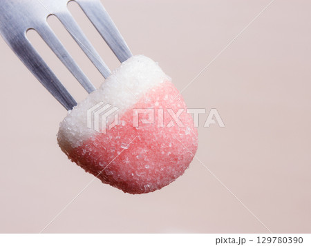 Pink jelly or marshmallow on fork closeup Pink jelly or marshmallow on fork closeup 129780390
