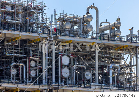 Oil and Gas refinery petrochemical plant industrial on blue sky background, Oil and Gas refinery petrochemical plant pipeline steel, Oil and Gas refinery factory maintenance, Global energy refinery. 129780448