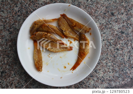 dried fish in basket and plate 129780523