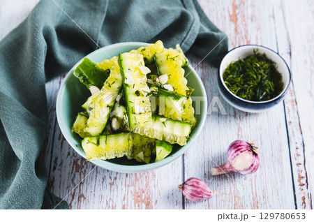 A bowl of spicy lightly salted cucumbers with herbs on the table A bowl of spicy lightly salted cucumbers with herbs on the table 129780653