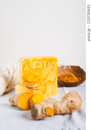 Natural homemade rejuvenating soap with turmeric on the table vertical view 129780681