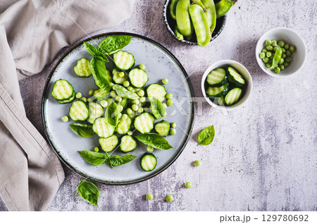 Antioxidant salad of fresh cucumbers, green peas and basil on a plate on the table top view Antioxidant salad of fresh cucumbers, green peas and basil on a plate on the table top view 129780692
