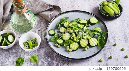 Antioxidant salad of fresh cucumbers, green peas and basil on a plate on the table web banner 129780696
