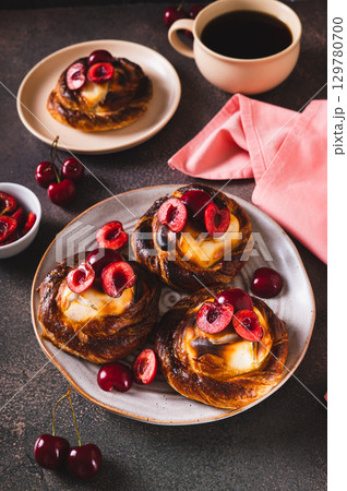 Homemade cherry cheesecakes on a plate on the table vertical view 129780700
