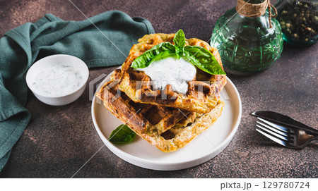 Homemade waffles with sour cream and basil on a plate on the table web banner 129780724