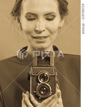 Woman taking picture with old camera Woman taking picture with old camera 129780729