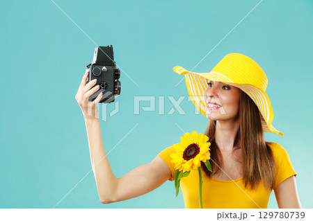 Summer woman holds sunflower old camera 129780739