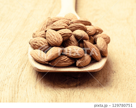 Almonds on wooden spoon Almonds on wooden spoon 129780751
