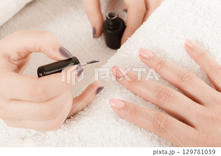 Woman in beauty salon getting manicure done. 129781039