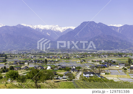 安曇野の町の風景と北アルプスの残雪の山並み 安曇野の町の風景と北アルプスの残雪の山並み 129781386