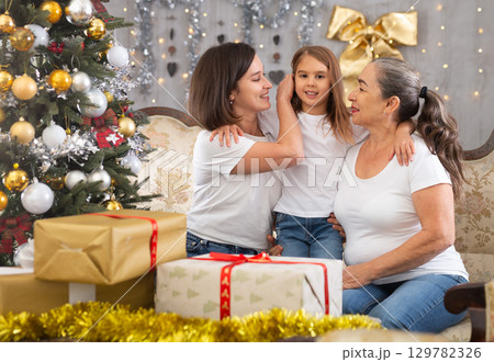 Grandmother mom and daughter on sofa in Christmas interior Grandmother mom and daughter on sofa in Christmas interior 129782326