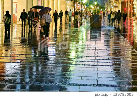 Belgrade, Serbia -- 05-25-2023: Vibrant reflections on a wet street at night in a city Belgrade, Serbia -- 05-25-2023: Vibrant reflections on a wet street at night in a city 129783003