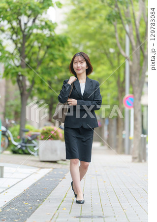 若い女性　ビジネス　屋外　歩く 129783084