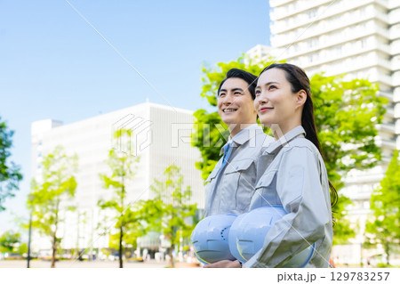新緑の街に立つ男女エンジニアのグループ 129783257