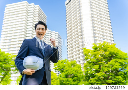ビルの前でガッツポーズする男性ビジネスパーソン ビルの前でガッツポーズする男性ビジネスパーソン 129783269