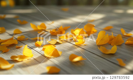 Bright yellow autumn leaves scattered on a wooden surface with natural light . Bright yellow autumn leaves scattered on a wooden surface with natural light . 129783592