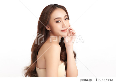 A beautiful young Asian woman with clean, fresh skin against a white background. Skincare, facial treatment, cosmetology, beauty, and spa. An elegant portrait of an Asian woman. A beautiful young Asian woman with clean, fresh skin against a white background. Skincare, facial treatment, cosmetology, beauty, and spa. An elegant portrait of an Asian woman. 129787448