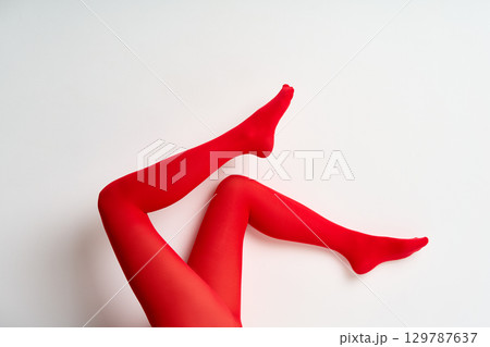 Long female legs oin red tights over white wall background. Long female legs oin red tights over white wall background. 129787637