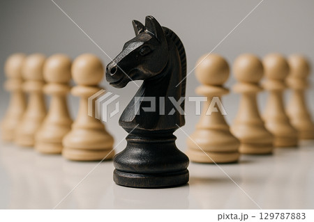 A black Knight chess piece in front of pawns representing guidance, wisdom, and strong leadership direction A black Knight chess piece in front of pawns representing guidance, wisdom, and strong leadership direction 129787883