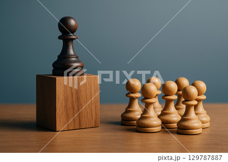 A black pawn chess on a pedestal with pawns below representing authoritative leadership recognition 129787887