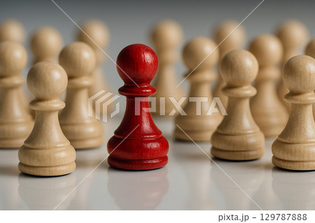 A red pawn among white pawns reflecting shared leadership and cooperation between bold individuals 129787888