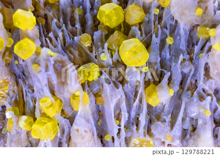 Close-up of Native sulfur vibrant yellow crystals on mineral surface, showcasing geometric shapes and contrasting colors. For backgrounds, geology studies, or educational materials Close-up of Native sulfur vibrant yellow crystals on mineral surface, showcasing geometric shapes and contrasting colors. For backgrounds, geology studies, or educational materials 129788221