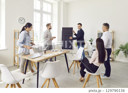 Businessman Consulting Team on Solar Panels in Office 129790136