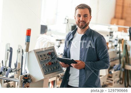 Skilled engineer. Handsome man is working at the factory of creating eco boxes 129790666