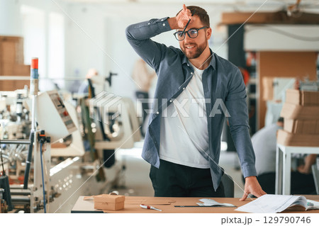 Conception of labor. Handsome man is working at the factory of creating eco boxes Conception of labor. Handsome man is working at the factory of creating eco boxes 129790746
