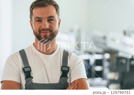 Close up portrait. Handsome man is working at the factory of creating eco boxes 129790781