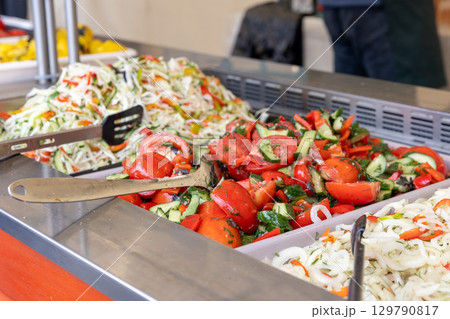 A variety of fresh, colorful salads on a buffet counter at a street food market. 129790817