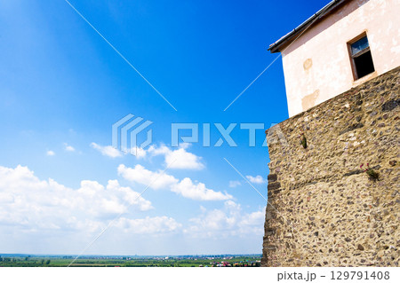 mukachevo, ukraine - may 25, 2008: palanok castle in summertime. old fortification now serves as the museum and is popular tourist landmark of transcarpathia region. urban scenery on a sunny day mukachevo, ukraine - may 25, 2008: palanok castle in summertime. old fortification now serves as the museum and is popular tourist landmark of transcarpathia region. urban scenery on a sunny day 129791408
