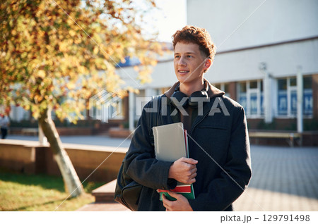 Young student is outside the university, in black clothes Young student is outside the university, in black clothes 129791498