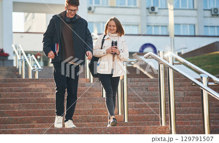 On the stairs. Two young students are together outdoors 129791507