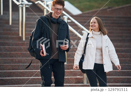 Having a break. Two young students are together outdoors Having a break. Two young students are together outdoors 129791511