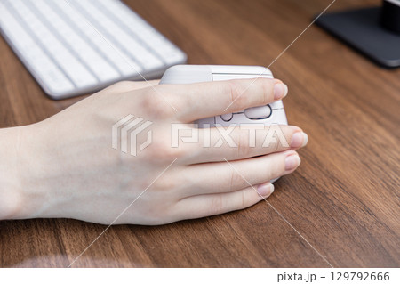 User hand operating comfortable vertical ergonomic computer mouse on wooden desk, symbolizing office health, productivity, and modern digital workspace setup User hand operating comfortable vertical ergonomic computer mouse on wooden desk, symbolizing office health, productivity, and modern digital workspace setup 129792666