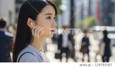 音楽を聴きながら外を歩いている女性 129793267