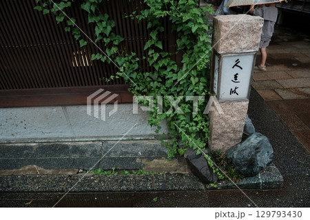 石柱とツタの絡まる町並み 129793430
