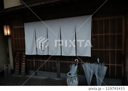 和風建築の店舗入口と白い暖簾と傘立て 和風建築の店舗入口と白い暖簾と傘立て 129793433
