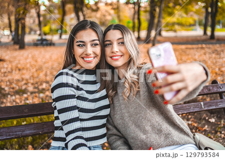 Two Women Taking a Picture With Their Cell Phone 129793584