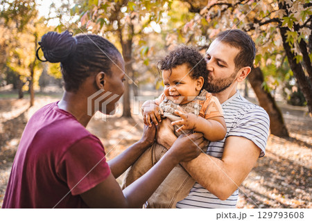 Boy in the arms of his parents in the park 129793608