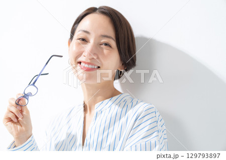 眼鏡を持った女性	 129793897