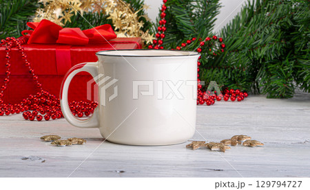 White mug standing on white wooden table with christmas decorations 129794727