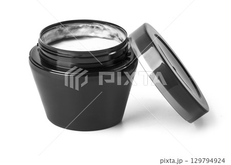 Open cosmetic cream jar displaying white cream on white background 129794924