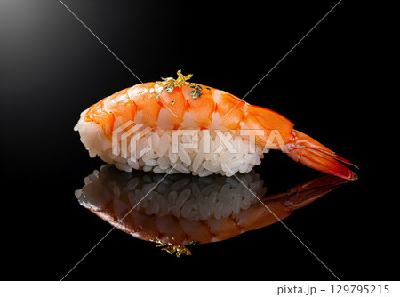 Gourmet Ebi Nigiri Sushi with Edible Gold Flakes on a Black Background 129795215
