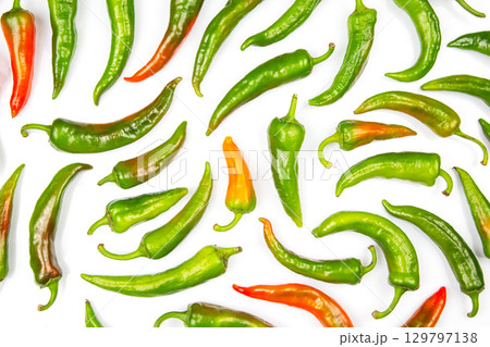 Vibrant assortment of green and red chili peppers on a white background arranged artistically Vibrant assortment of green and red chili peppers on a white background arranged artistically 129797138