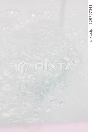 Bubbles Rising Gracefully in Clear Water with a Gentle Swirl Motion 129797341