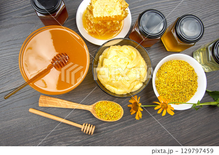 Natural honey, beeswax, and pollen collection with various products on wooden table 129797459