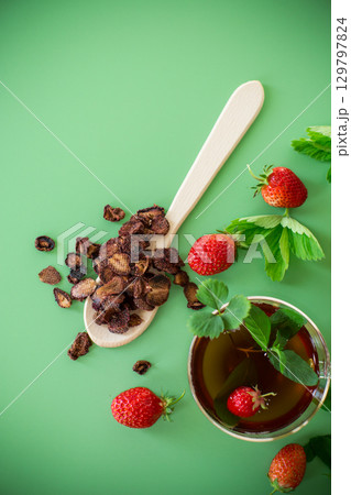 Aromatic herbal drink with berries on a green background 129797824