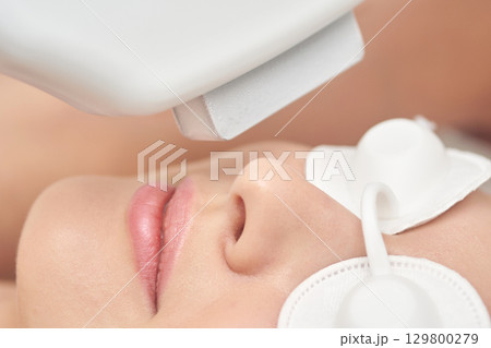 Close-up of female undergoing facial laser treatment for skin care 129800279